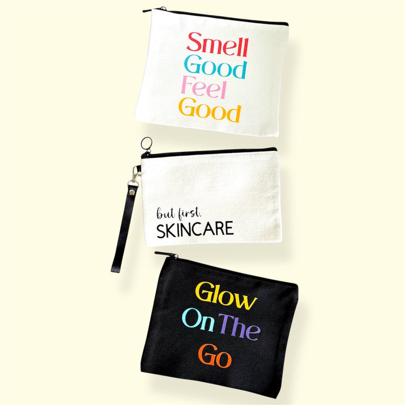 Three Finishya canvas skincare travel pouches with slogans: "Smell Good Feel Good", "but first, SKINCARE", and "Glow On The Go"; vegan-friendly accessories made in NZ.