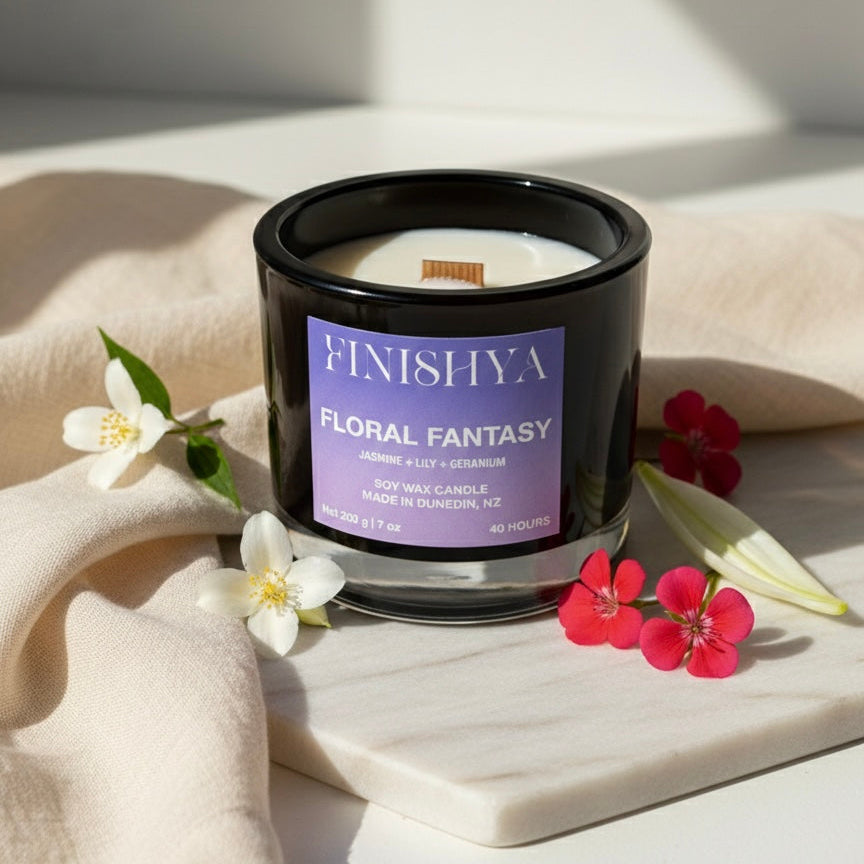 Three Finishya hand-poured soy wax candles in black glass jars: Floral Fantasy, Golden Glow, and Candy Clouds, made in NZ.
