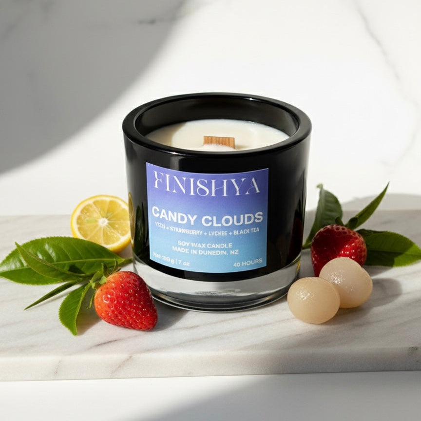 Finishya Candy Clouds candle styled with fresh yuzu, strawberries, and lychee fruit on a marble surface to represent the fragrance profile.
