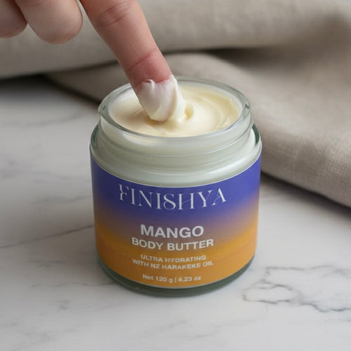 A finger scooping a thick swirl of Finishya Mango Body Butter, highlighting the rich and buttery consistency of this vegan skincare product.