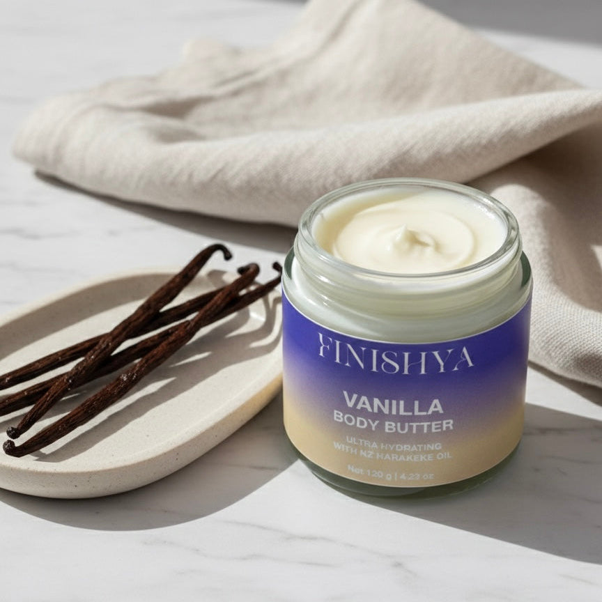 An open jar of thick, creamy white vanilla body butter next to whole vanilla beans on a marble surface.