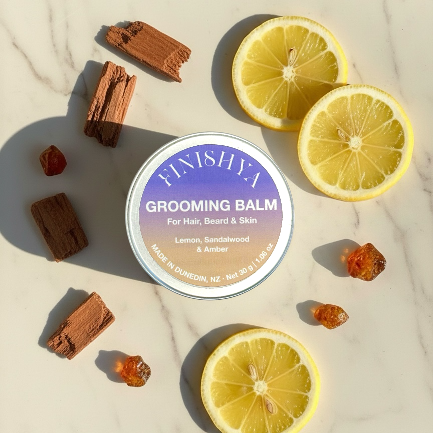 Finishya Grooming Balm flatlay with lemon slices and sandalwood pieces to illustrate the amber and citrus fragrance.