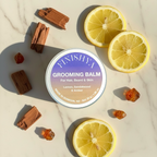 Finishya Grooming Balm flatlay with lemon slices and sandalwood pieces to illustrate the amber and citrus fragrance.