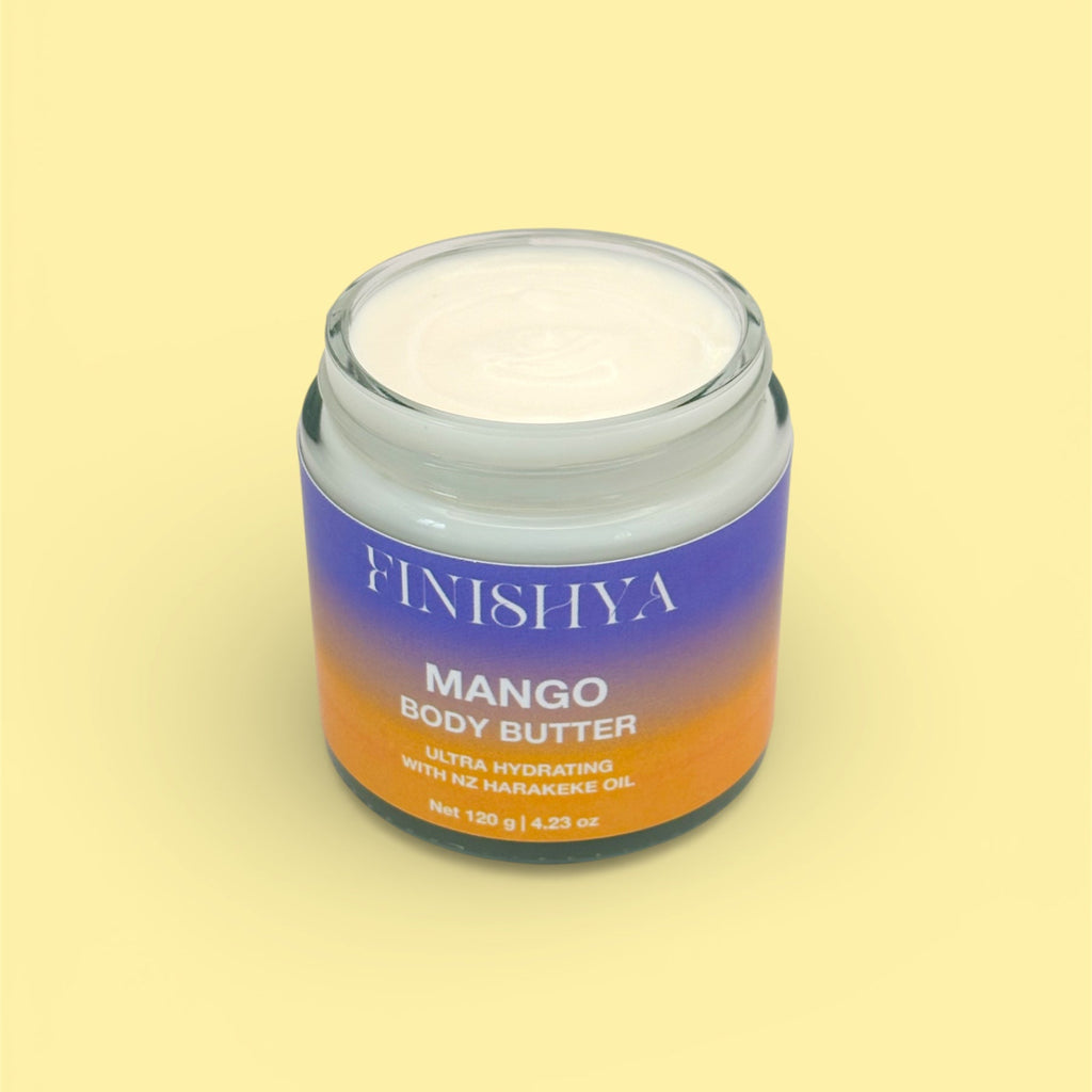 Top-down view of an open jar of Finishya Mango Body Butter featuring NZ Harakeke Oil, 120g glass jar on a yellow background.