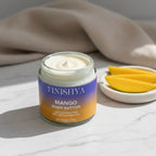 Finishya Mango Body Butter jar styled with fresh mango slices on a marble surface, emphasizing the tropical scent and nourishing ingredients.