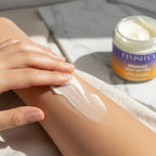 Close-up of Finishya Mango Body Butter being applied to a forearm, showing a creamy, non-greasy texture for sensitive skin hydration.