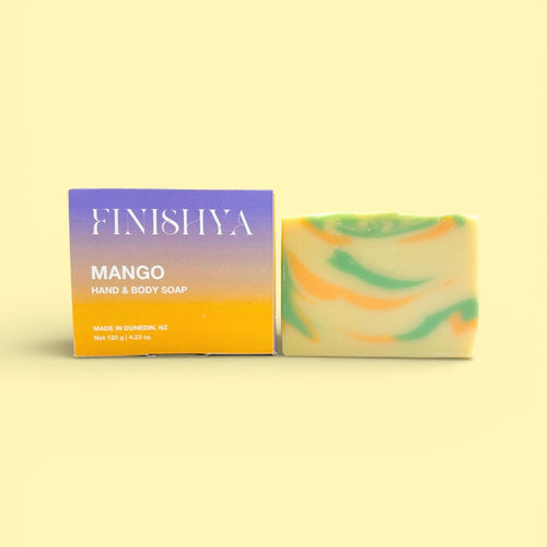 Finishya Mango hand and body soap bar next to its purple and orange sunset-themed box, labeled "Made in Dunedin, NZ."