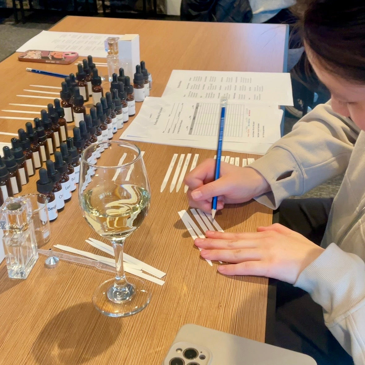 A participant writing down a custom fragrance formula at a Finishya perfume experience in Dunedin.