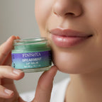 Close up of a model holding Finishya Spearmint Lip Balm, highlighting a glossy and hydrated finish for sensitive lips.