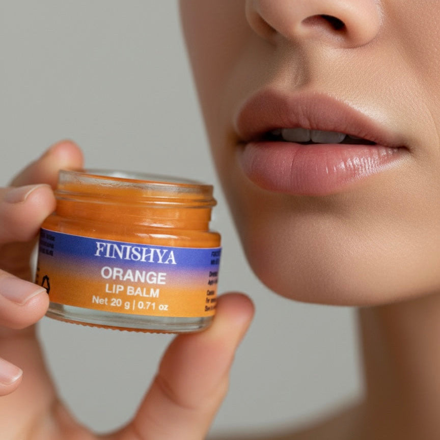 Model holding a jar of Finishya Orange Lip Balm near lips. Hydrating and soothing lip care for dry lips.
