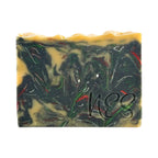 Close-up of NES Midnight Bloom handmade soap showing its dark floral swirl design with hints of gold and red.

