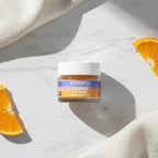 Aesthetic flatlay of Finishya Orange Lip Balm on white marble with orange slices. Scented vegan skincare made in NZ.