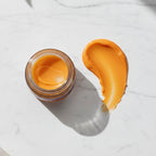 Smooth orange texture swatch of Finishya Lip Balm on a white marble surface. Cruelty-free and suitable for sensitive skin.