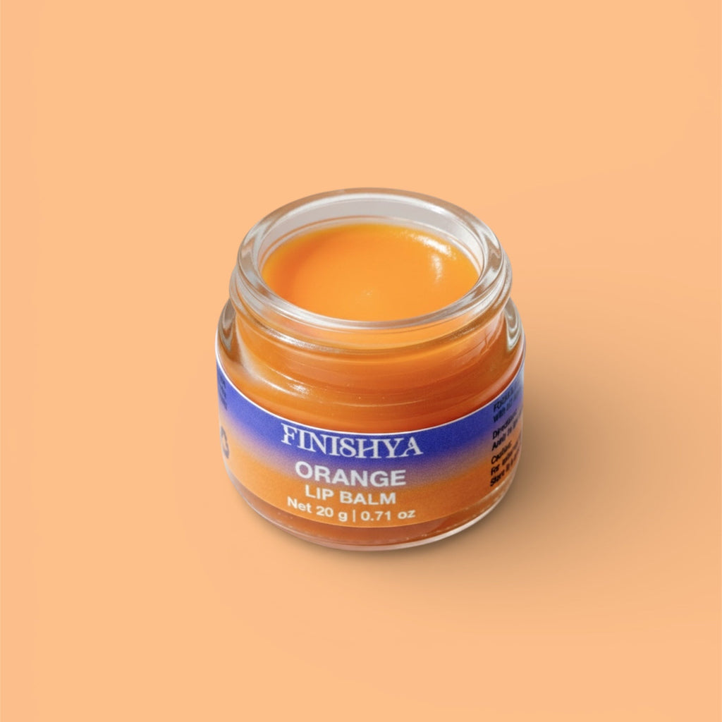 Close-up of an open jar of Finishya Orange Lip Balm showing a rich, buttery texture. Nourishing vegan lip treatment.